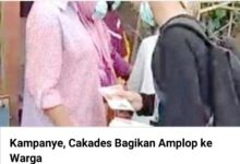 Seorang pria membagikan amplop saat hari H kampanye terbuka Cakades tanjakan Rajeg Tuti Astuti saya banyak uang