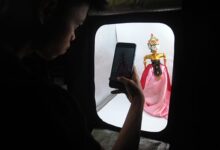 Perajin memotret produk wayang golek yang dipesan melalui pasar daring di UKM Golek Waris