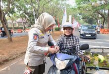 SatPOL PP memberikan bendera merah putih kepada warga.